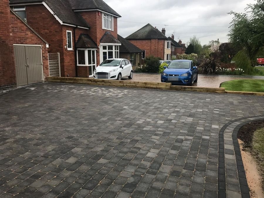 Charcoal block paved driveway with contrasting border course