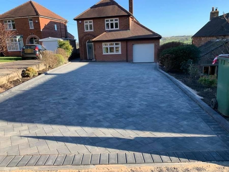 Block paved driveway with charcoal border and drainage channel